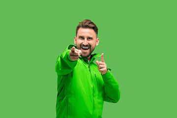 Image showing handsome bearded young man looking at camera isolated on green