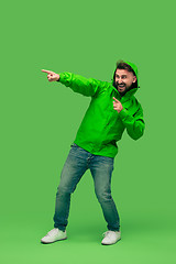 Image showing handsome bearded young man looking at camera isolated on green