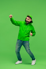 Image showing handsome bearded young man looking at camera isolated on green