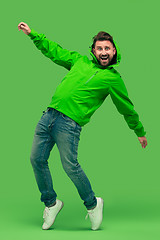 Image showing handsome bearded young man looking at camera isolated on green