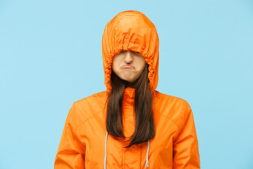 Image showing The young girl posing at studio in autumn jacket isolated on blue