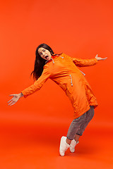 Image showing The young girl posing at studio in autumn jacket isolated on red