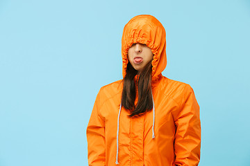 Image showing The young girl posing at studio in autumn jacket isolated on blue