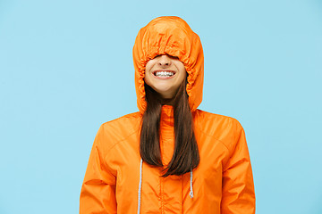 Image showing The young surprised couplel posing at studio in autumn jackets isolated on blue