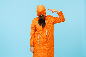 Image showing The young girl posing at studio in autumn jacket isolated on blue