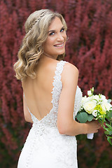 Image showing Wedding. Beautiful bride in white dress holding wedding bouquet.