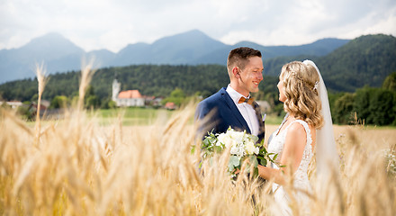 Image showing Groom hugs bride tenderly in wheat field somewhere in Slovenian countryside.