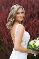 Image showing Wedding. Beautiful bride in white dress holding wedding bouquet.