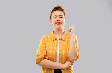 Image showing red haired teenage girl pointing finger up