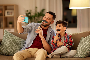 Image showing father and son taking selfie at home