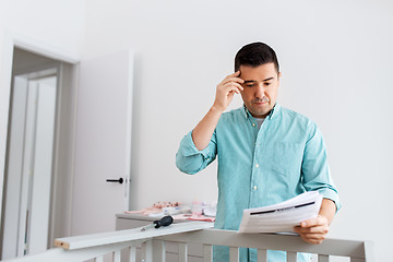 Image showing father with manual assembling baby bed at home