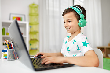 Image showing boy in headphones playing video game on laptop