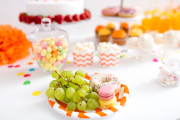 Image showing grapes, macarons and donut on party table