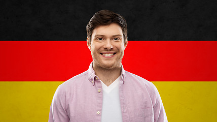 Image showing smiling young man over german flag colors