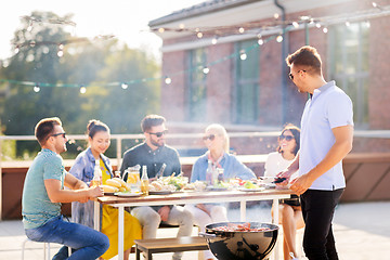 Image showing man grilling meat on bbq at rooftop party