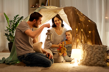 Image showing happy family playing in kids tent at night at home