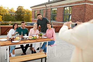 Image showing happy friends photographing at rooftop party