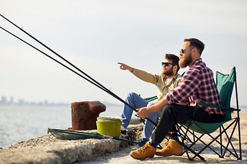 Image showing happy friends with fishing rods on pier