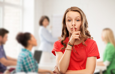 Image showing teenage girl in red t-shirt with finger on lips