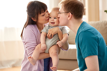 Image showing happy mother and father kissing baby son at home