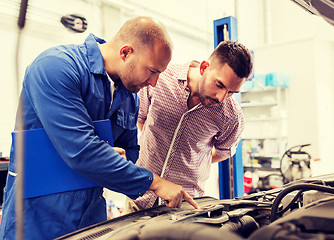 Image showing auto mechanic with clipboard and man at car shop