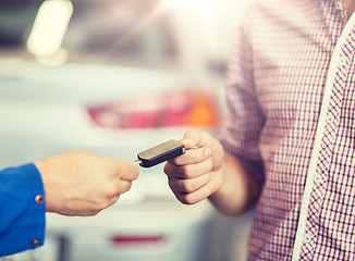 Image showing auto mechanic giving car key to man at workshop