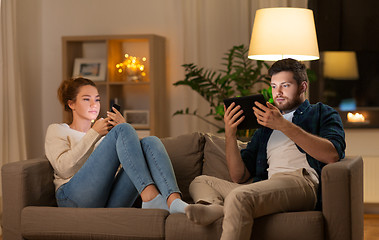 Image showing couple with tablet computer and smartphone at home