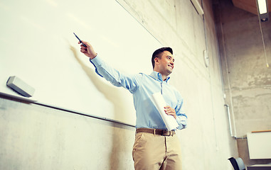 Image showing teacher pointing marker to white board at lecture