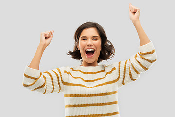 Image showing happy young woman in pullover celebrating success