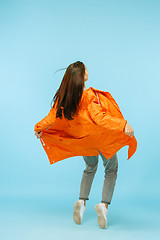 Image showing The young girl posing at studio in autumn jacket isolated on blue