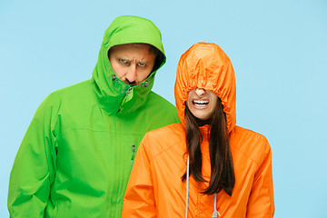 Image showing The young couplel posing at studio in autumn jackets isolated on blue