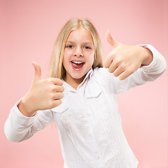 Image showing The happy teen girl standing and smiling against pink background.