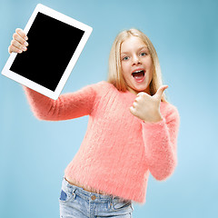 Image showing Little funny girl with tablet on blue background