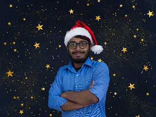 Image showing Indian man wearing traditional Santa Claus hat with stars in bac