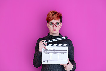 Image showing woman holding movie clapper isolated on pink background