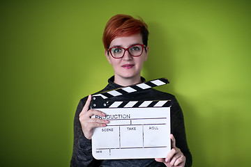 Image showing woman holding movie clapper against green background