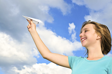 Image showing Young girl holding paper airplane