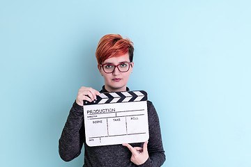 Image showing woman holding movie clapper against cyan background