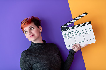 Image showing woman holding movie clapper against colorful background