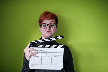 Image showing woman holding movie clapper against green background