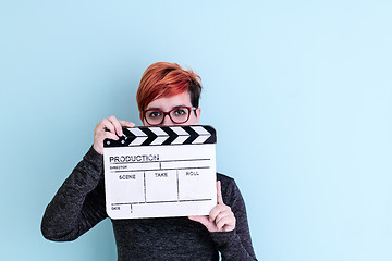 Image showing woman holding movie clapper against cyan background