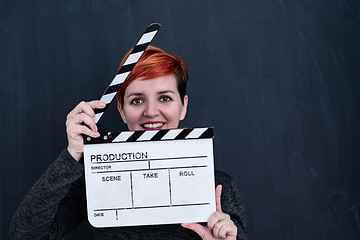 Image showing redhead woman holding movie clapper