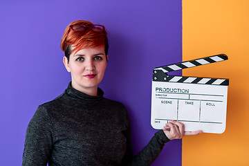 Image showing woman holding movie clapper against colorful background