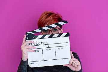 Image showing woman holding movie clapper isolated on pink background