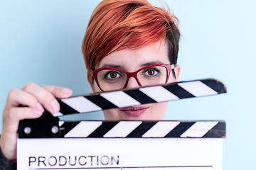 Image showing woman holding movie clapper against cyan background