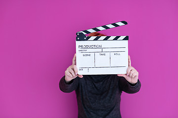 Image showing woman holding movie clapper isolated on pink background