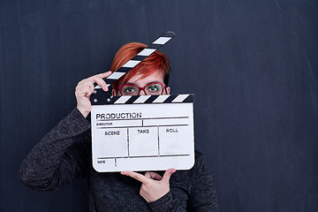 Image showing redhead woman holding movie clapper