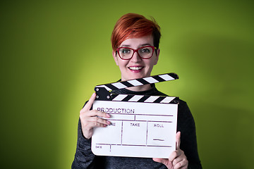 Image showing woman holding movie clapper against green background