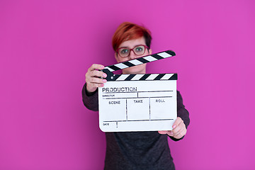 Image showing woman holding movie clapper isolated on pink background