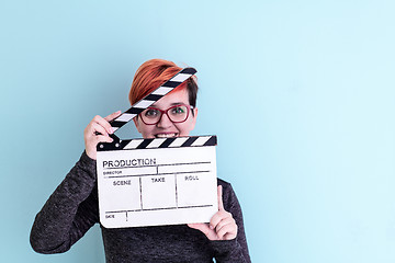 Image showing woman holding movie clapper against cyan background